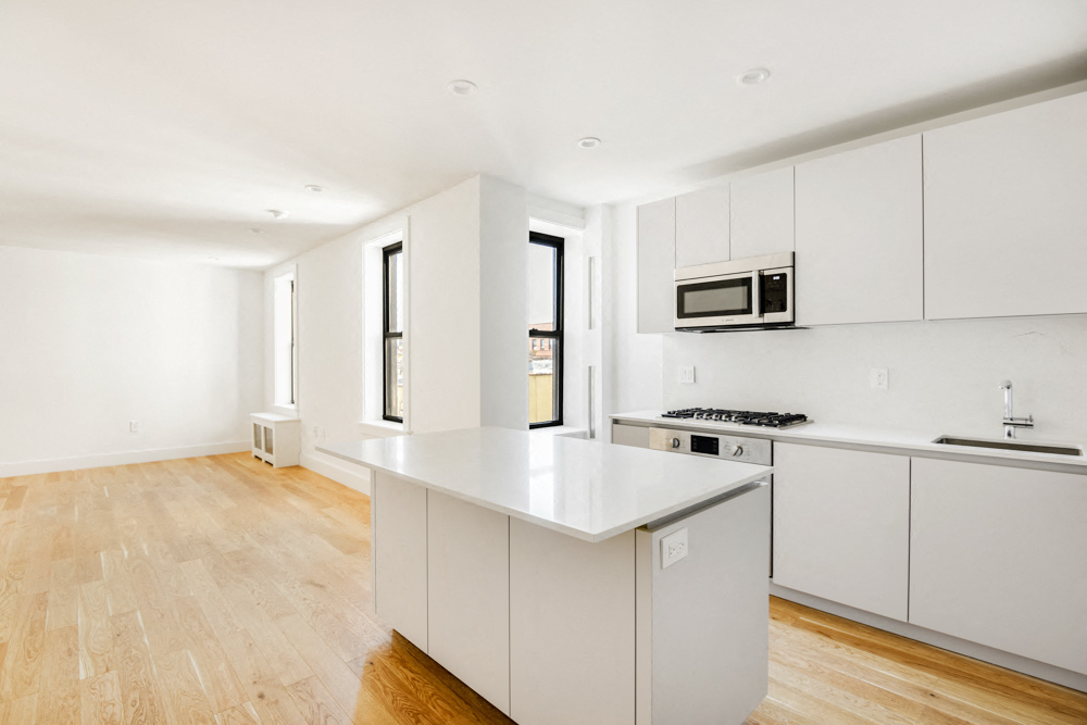 a white kitchen with white cabinets and a white counter top